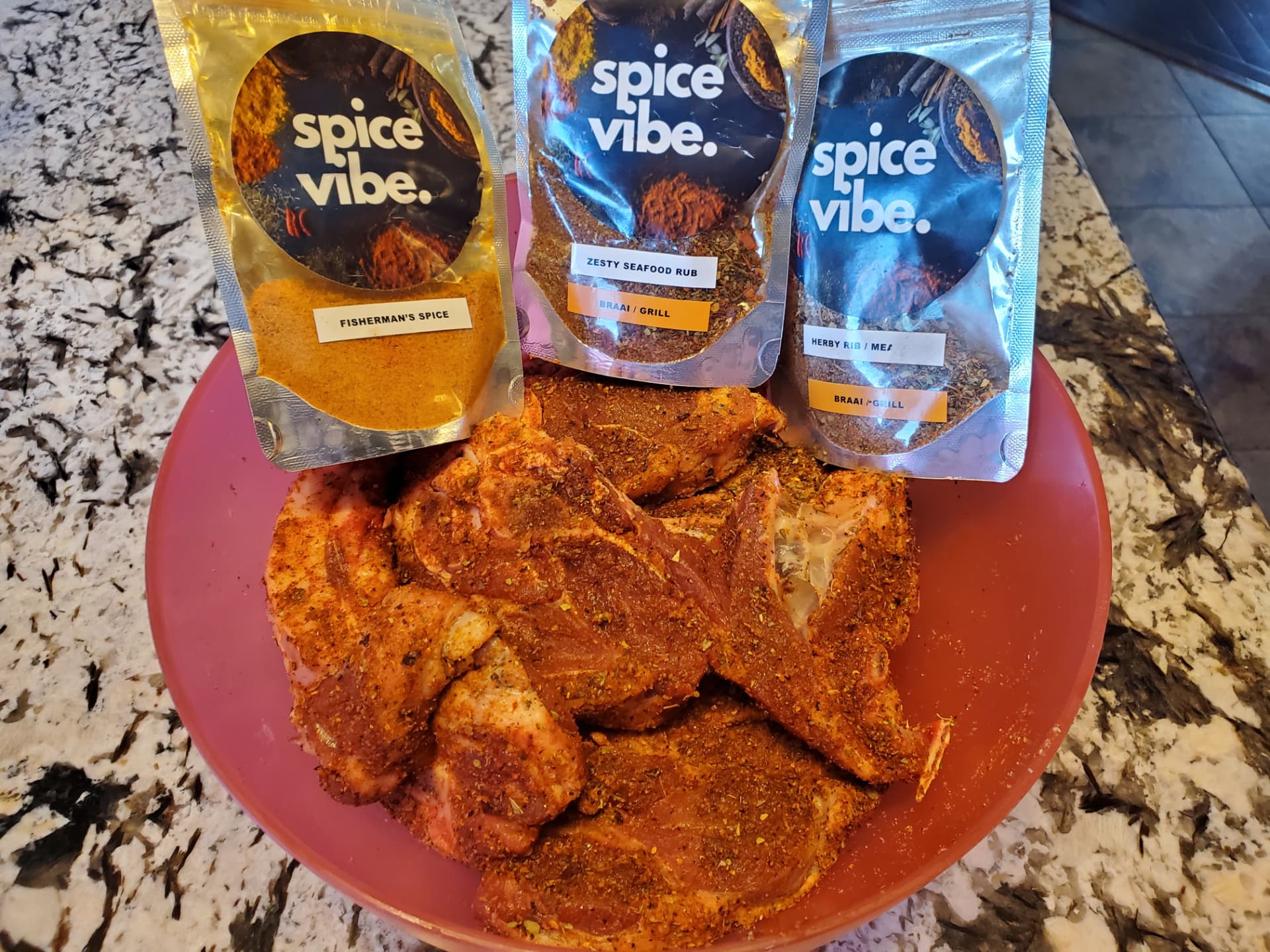 Three Spice World pouches beside a bowl of freshly seasoned chops